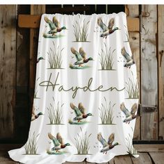 a white shower curtain with ducks and grass on it that says, happolen