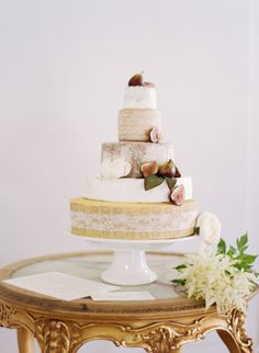 a wedding cake sitting on top of a table next to a vase with white flowers