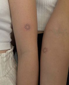 two women with matching tattoos on their arms