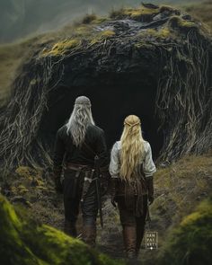 two people standing in front of a cave