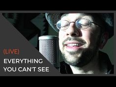 a man wearing glasses and a hat is in front of a microphone with the words live everything you can't see