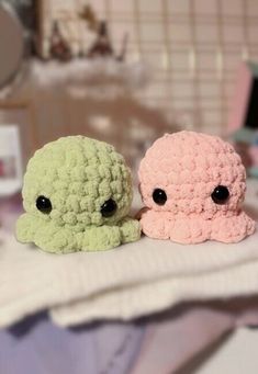 two small crocheted animals sitting next to each other on top of a table