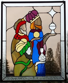 a stained glass window with an image of two people holding hands and looking at the sky