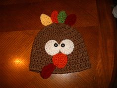 a crocheted turkey hat on top of a wooden table