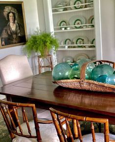 a basket on top of a wooden table in a room with white walls and chairs