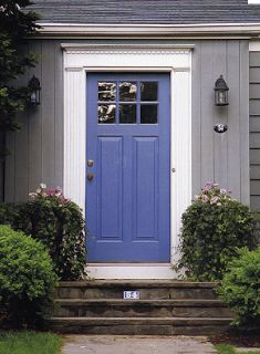 a blue front door on a gray house