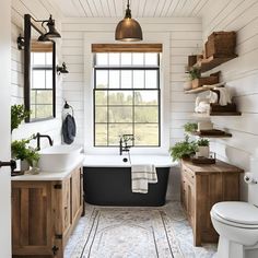 a bath room with a toilet a sink and a tub next to a window on the wall