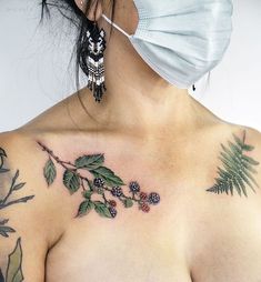 a woman wearing a face mask and tattoos on her chest