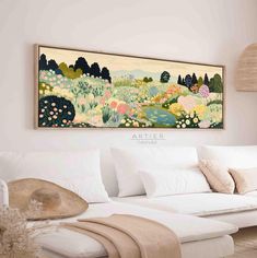 a painting hanging on the wall above a white couch in a living room with pillows