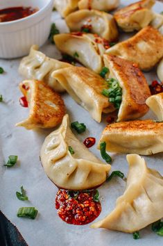 some dumplings are sitting on a plate with dipping sauce