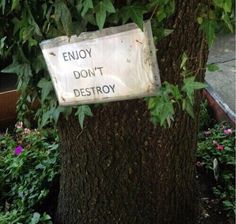 a sign on a tree that says enjoy don't destroy