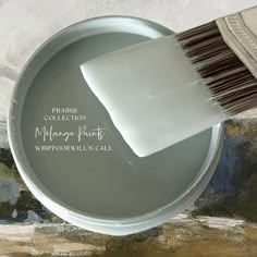 a paint can with a brush on top of it