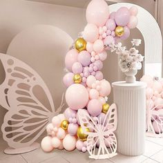 balloons and flowers are arranged in the shape of a butterfly on display at a party