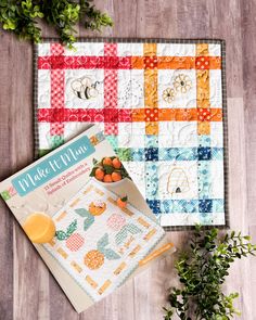 two quilted placemats on a wooden floor with oranges and an orange juice