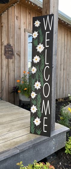 a welcome sign sitting on top of a wooden porch