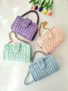 three crocheted purses sitting next to each other on a white counter top