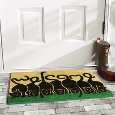 a door mat with cats on it next to a pair of boots and booties