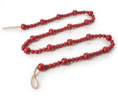 a long red beaded necklace on a white surface with a string attached to it