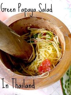 a wooden bowl filled with noodles and vegetables