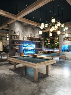 an indoor pool table with lights hanging from it's ceiling and two billiards tables in the foreground