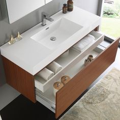 a bathroom vanity with two drawers and a sink in front of a window that looks out onto the yard