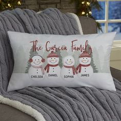 three snowmen are shown on the pillow in front of a couch with christmas lights