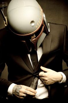 a man wearing a suit and tie with a helmet on his head