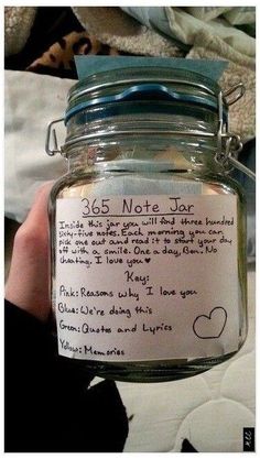 a person holding a jar with writing on it and a note attached to the lid