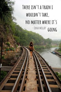 a woman walking on train tracks with a quote