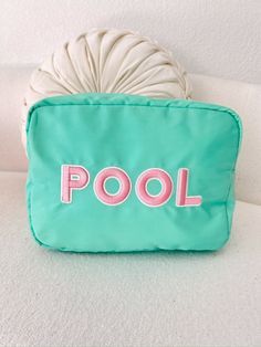 The ultimate poolside bag for sunscreen, mini speaker, snacks and even wet bikinis!  XL Teal nylon with pink rolled patches sewn on Dimensions:      11 x 5 x 8 inches Pink Poolside Bags For Beach Season, Green Poolside Bags For Beach Season, Pink Nylon Bag For Summer, Summer Pink Nylon Bags, Summer Pink Bags For Poolside, Playful Nylon Travel Bags, Playful Travel Cosmetic Pouch Bag, Summer Nylon Pouch Bag, Pink Nylon Travel Cosmetic Bag