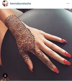 a woman's hand with henna tattoos on it