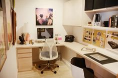 a home office area with desk, chair and computer on the wall above the desk