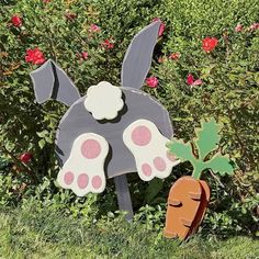 a wooden sign with a dog's paw on it and a carrot in the grass