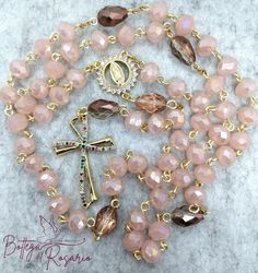 Beautiful handmade Rosary bounded in  gold brass. The beads are pink crystals about 07 mm, and the pater's bead are tears. The centerpiece is dedicated to virgin of Guadalupa and the final cross are in gold brass and cubik zirconia Handmade Pink Cross Rosary, Affordable Handmade Pink Rosary, Pink Rosary With 8mm Beads As Gift, Handmade Pink Rosary With Round Beads, Handmade Pink Spiritual Rosary, Rosary Boxes, Handmade Rosary, Rosary Necklace, Gold Brass