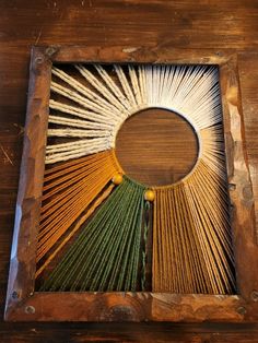 an art work made out of yarn and wood with sunbursts in the center