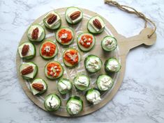 cucumbers with cream cheese and pecans on a cutting board