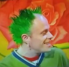 a man with green hair and piercings on his head