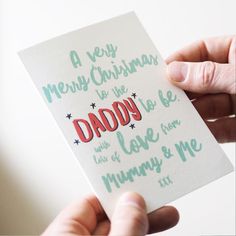 a person holding up a card that says merry christmas for the daddy and i love you mommy and me