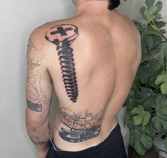 a man with a tattoo on his back has a wrench in the shape of a skeleton