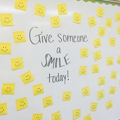 a white board with yellow post it notes and smiley faces on it that says give someone a smile today