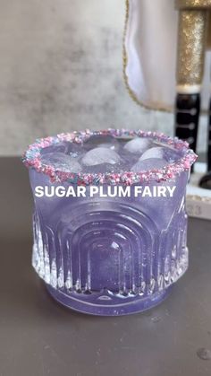 there is a purple cake with sprinkles on it and the words sugar plum fairy