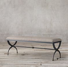 a bench sitting on top of a wooden floor next to a cement wall and wood floor