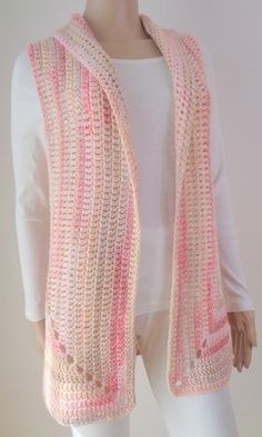 a white mannequin wearing a pink and beige striped knitted vest with buttons