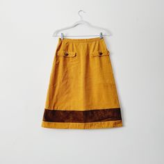 60s/70s mustard yellow or tan corduroy skirt, either knee length or below-the-knee. Handmade with metal zipper closure in the back. Has two faux pockets in the front with metal buttons and a brown corduroy banded strip along the bottom.  No size tag - fits like medium 13 inches across the waist,  26 inches full length Check out other listings in my shop for more vintage clothing, home decor, and more: Uprightvintagemi.etsy.com **Please read the item description and title, view all photos and video, and reach out with any questions before purchasing! Our shop cannot accommodate returns.** **Follow us on instagram @uprightvintagemi for sneak peaks and behind-the-scenes content Length Check, Orange Skirt, Brown Corduroy, Skirt Vintage, Corduroy Skirt, Metal Zipper, Vintage Yellow, Metal Buttons, Yellow Orange