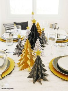 an advertisement for a christmas party with paper trees on the table and gold place mats