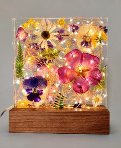 an illuminated glass box with flowers on it