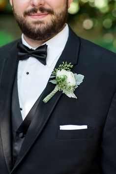 a man in a tuxedo with a boutonniere on his lapel