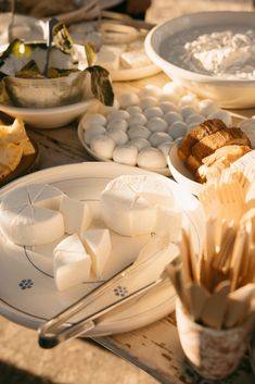 there are many plates that have marshmallows on them and bread in bowls