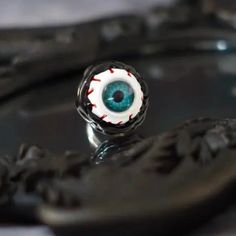 an eyeball ring sitting on top of a black tray