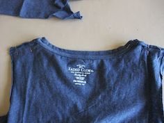 the back of a blue shirt with white writing on it and two pieces of clothing laying next to each other